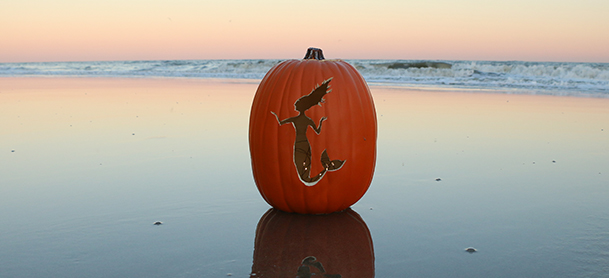 A carved pumpkin on the beach