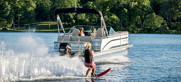 A Harris pontoon boat pulling a waterskier
