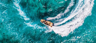 Aerial shot of a boat cruising in a circle, leaving a wake behind it.