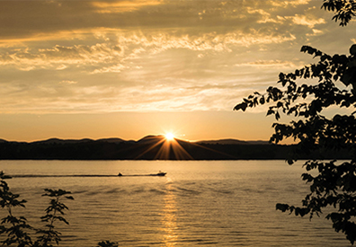 sun setting behind silhouette of mountain