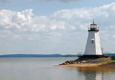 small white lighthouse on the shore