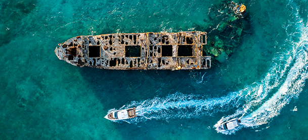 Aerial view of 2 small boats navigating through the deep blue ocean waters.