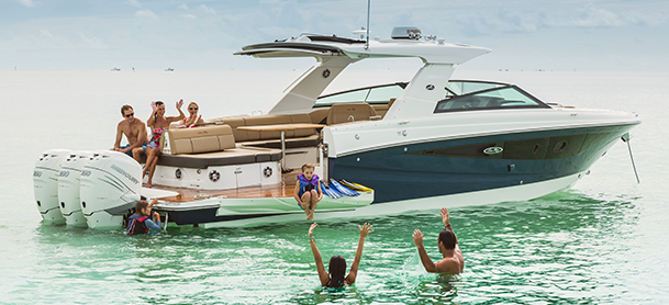 A group of people swimming together near a boat in clear blue water.