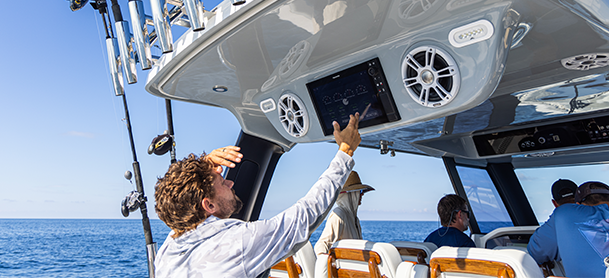 Fishermen on a boat while one is utilizing GPS navigation.