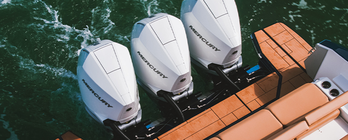 Three mercury engines on the back of a boat in the water