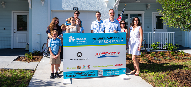 MarineMax team members pictured with the future home of the Peterson family.