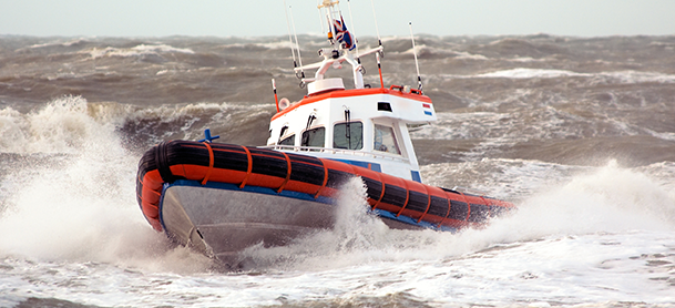 a coast guard boat ripping through rough waters