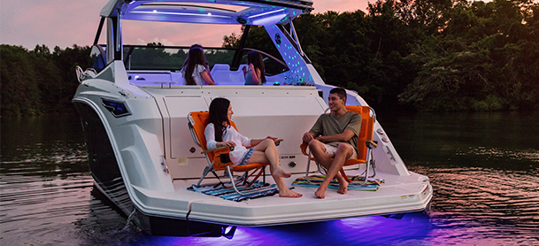 Boaters relaxing on the back of their vessel as the sun sets