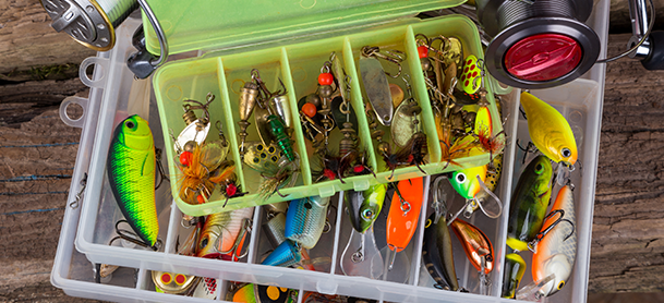 a variety of colorful fishing lures organized in translucent tackle boxes