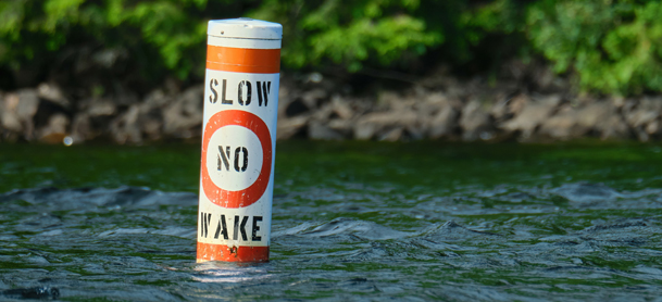 A no wake sign sits in the water