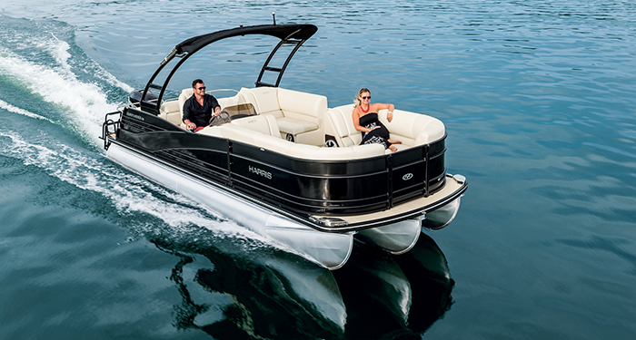 A couple cruising on clear water on a tritoon boat