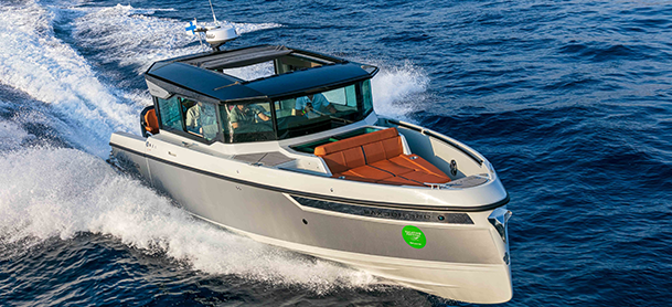 A Saxdor 320 GTC speeds through blue ocean waves, featuring a sleek gray exterior and brown seating, conveying excitement and luxury.