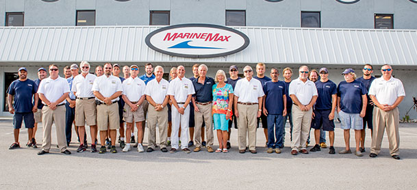 A group of MarineMax team members lined up outside of the store, with the MarineMax logo in the background