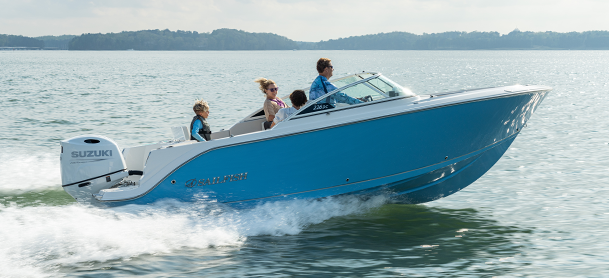 A blue motorboat with four people, including a child in a life jacket, speeds across a calm lake.