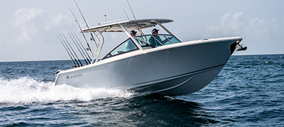 A white Sailfish boat moves across the water