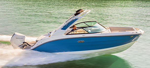 A blue and white SDX 230 with a Mercury outboard engine glides swiftly over calm, green water, evoking a sense of freedom and adventure.