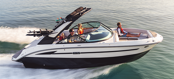 An SDX 230 Surf speeds across calm water, carrying three passengers.
