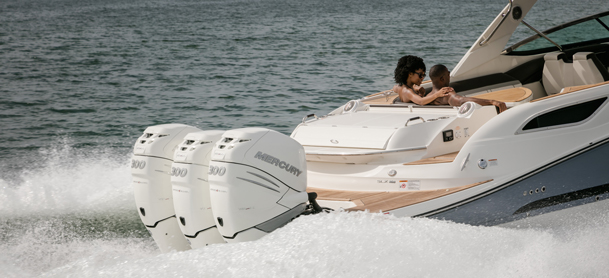 three mercury outboards stir up waves as they propell boat at lightning speed across water