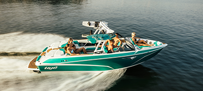 A green Tige boat sails across the water