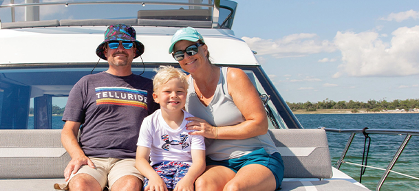family smiling at the front of Galeon Yacht