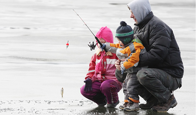 father and kids ice fishing