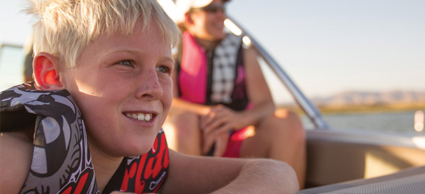 kid sitting in boat wearing life jacket
