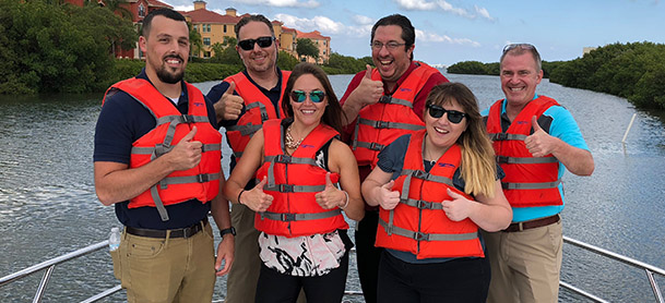 group of people wearing life jackets standing on boat