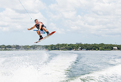 Wakeboarder in air behind boat