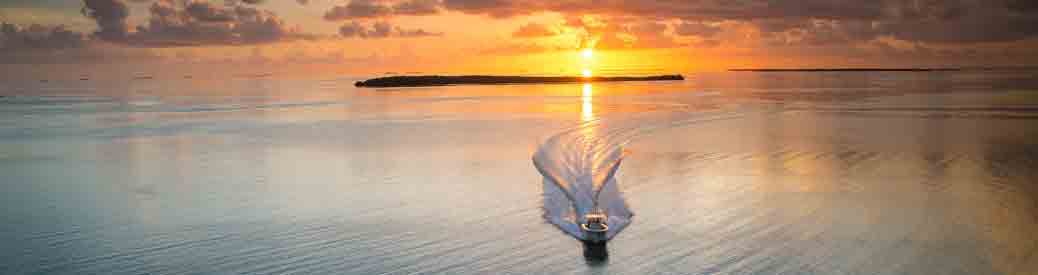 boat running on water with sunset in background