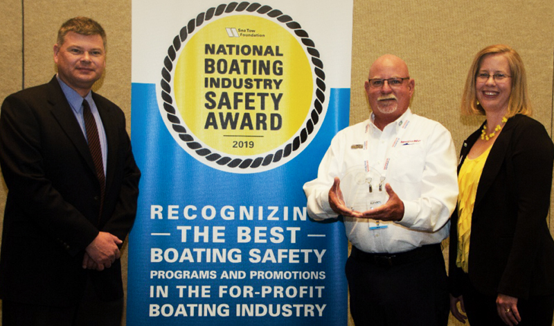 a marinemax team member holding a boating safety trophy