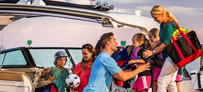 Family on dock, as dad lifts up young girl in life jacket