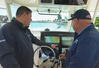 Two men using a Raymarine screen on a boat