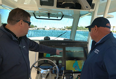 Two men pointing at a boat navigation screen