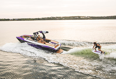 A Tige boat with a wakesurfer behind it