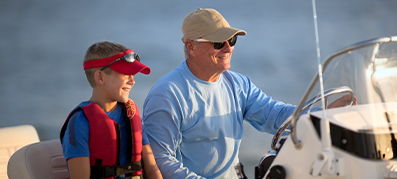 A man and boy at the helm of a boat