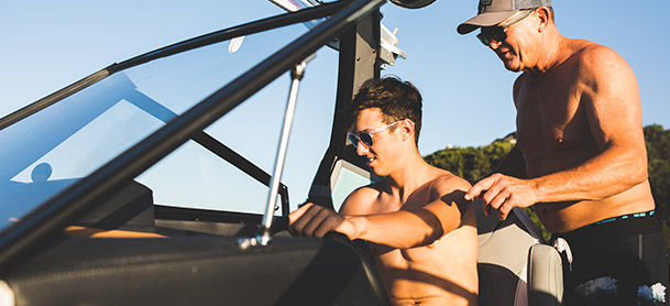 father and sun by the helm of a tige boat