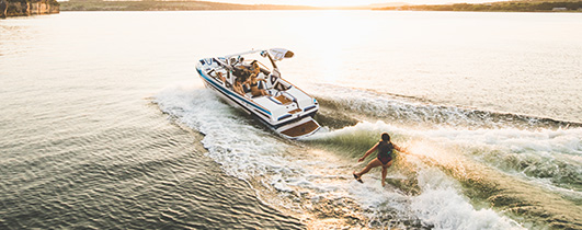 a tige boat in the water and children waterskiing