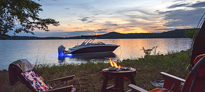 Sunset over a tranquil lake with a boat gently floating near the shore.