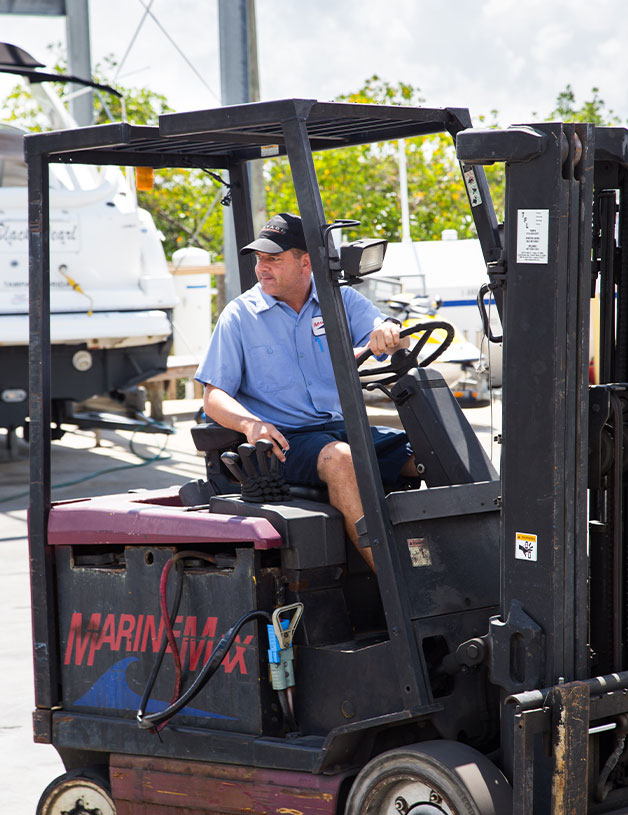 MarineMax Service Technician driving a forklift