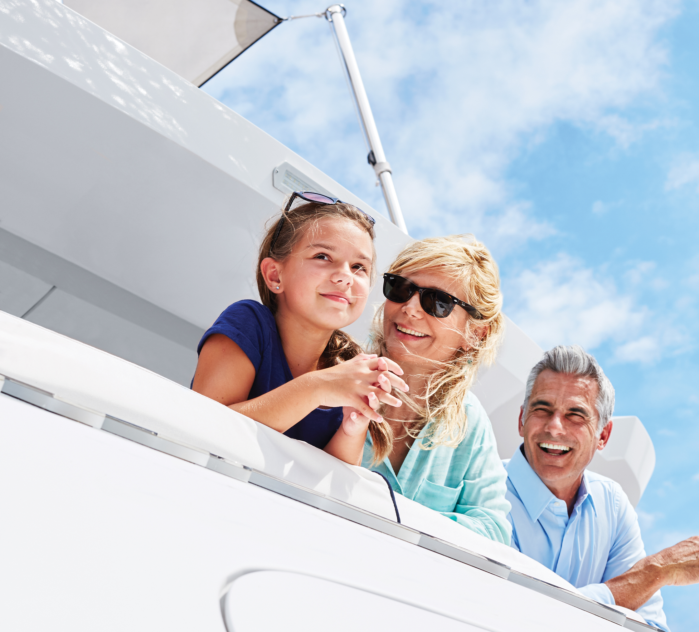 Man woman and child smiling by edge of boat