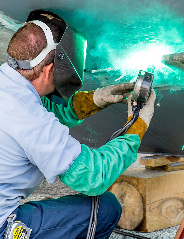 MarineMax service team member working on metal work on boat