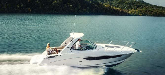 Boat cruising along densely forested coastline