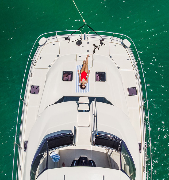 Overhead view of a power catamaran with lady on bow