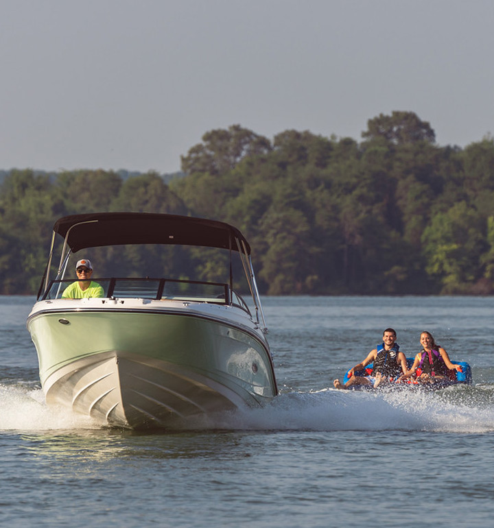 Sea Ray Sport Boat with couple on Tube behind it