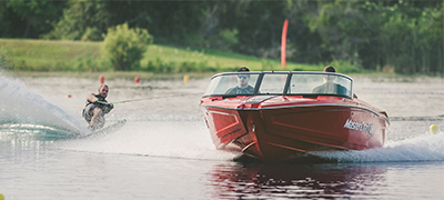 man waterskiing behind boat