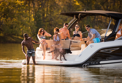 Dog on Sea Ray yacht shaking water from its body sprays delighted group of people