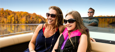 Family boating on lake with leaves changing color for fall.