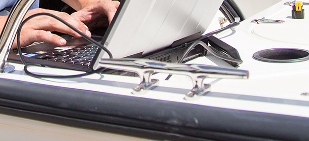 Person typing on a computer on board of a boat
