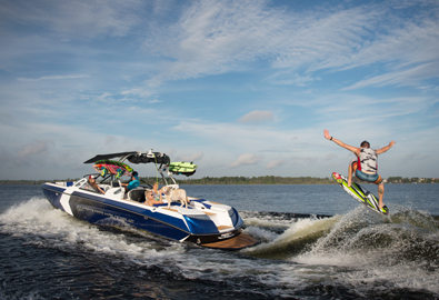 Family watches as man wakeboards behind super air nautique boat