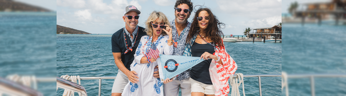 Group of people on side of a boat with MarineMax burgee